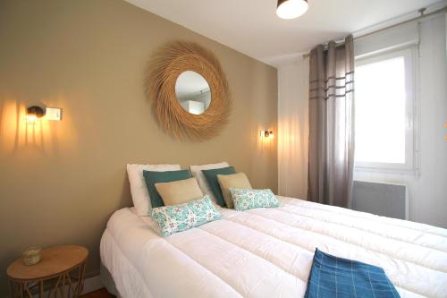 um quarto com uma grande cama branca e um espelho em Appart 2 chambres - Le Quai des Chartrons em Bordeaux