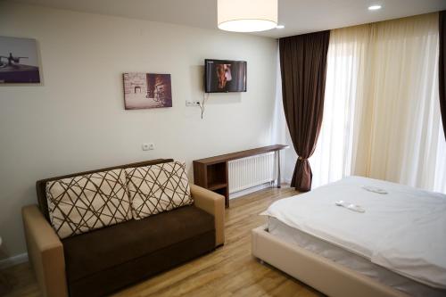 1 dormitorio con cama y sofá en Apartment 528 Orbi Palace, en Bakuriani