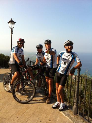 a group of men standing next to a fence with their bikes at San Pietro in Mileto