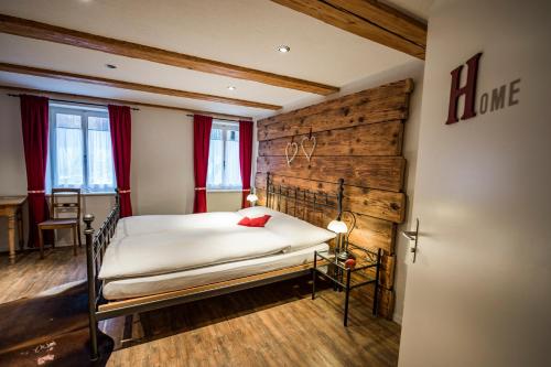 a bedroom with a bed with a wooden wall at B3 Boutique-Bed&Breakfast in Gsteigwiler