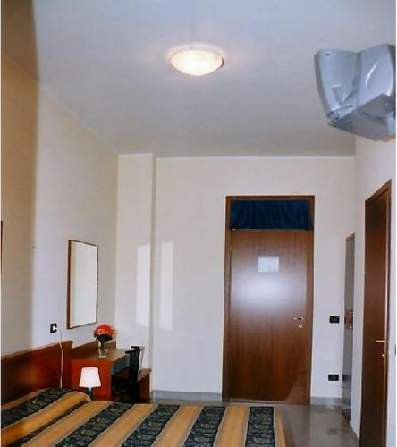a bedroom with a bed and a wooden door at Hotel Greco in Milan