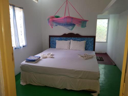 1 dormitorio con 1 cama con 2 toallas en Nilaveli Beach Rooms, en Nilaveli