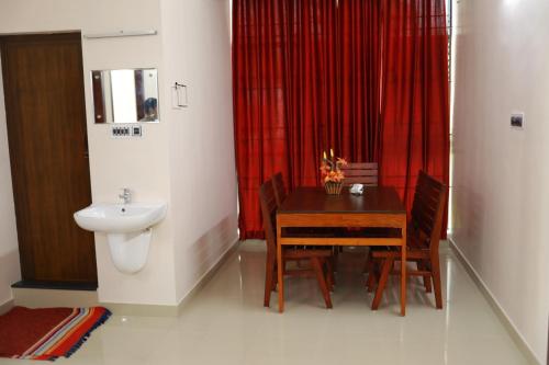 a bathroom with a table and a sink and a toilet at Indeevaram Residency in Trivandrum
