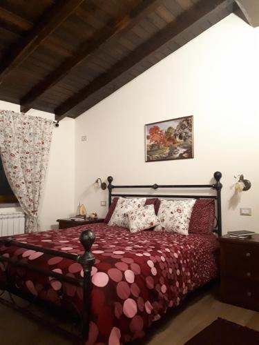 a bedroom with a bed with a red comforter at La Camelia B&B in Velletri