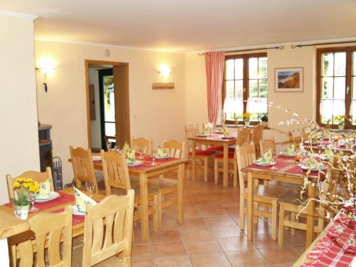 comedor con mesas y sillas de madera en Wirtshaus Neuenkirchen, en Neuenkirchen auf Rugen