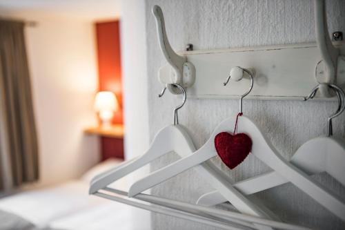 a heart hanging on hangers in a bedroom at B3 Boutique-Bed&Breakfast in Gsteigwiler
