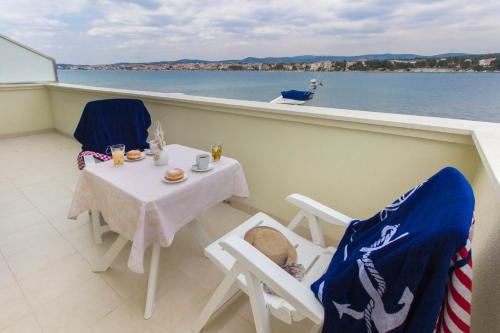 a balcony with a table and chairs on a boat at Riva in Krapanj