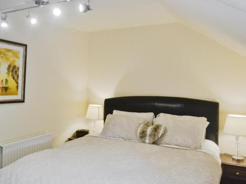 A bed or beds in a room at Blossom Cottage 