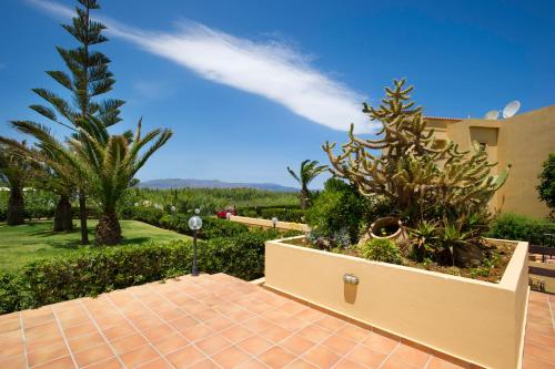 a house with palm trees and a walkway at Silver Beach Hotel & Apartments in Gerani Chanion
