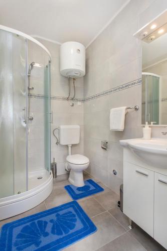 a bathroom with a toilet and a shower and a sink at Riva in Krapanj