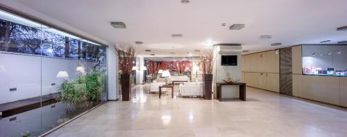a large hallway with a table and chairs in a building at Hotel Colon Rambla in Santa Cruz de Tenerife