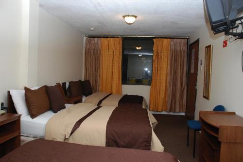 a hotel room with a bed and a couch at Hotel Bonaventure in Quito