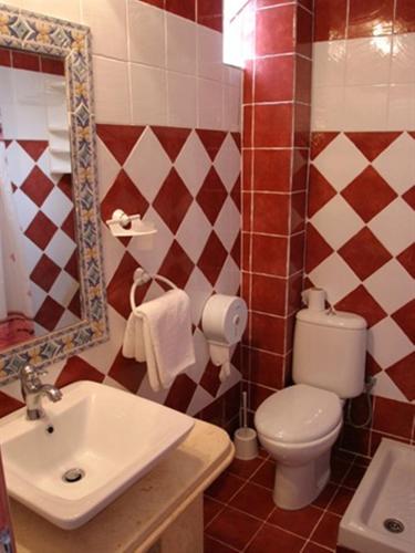 a bathroom with a toilet and a sink and a mirror at Philoxenia Village Hotel-Studios in Pefkochori