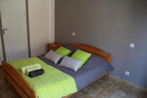 - une chambre dotée d'un grand lit avec des draps verts et gris dans l'établissement Chambre d'hote de la Fage, à La Fage