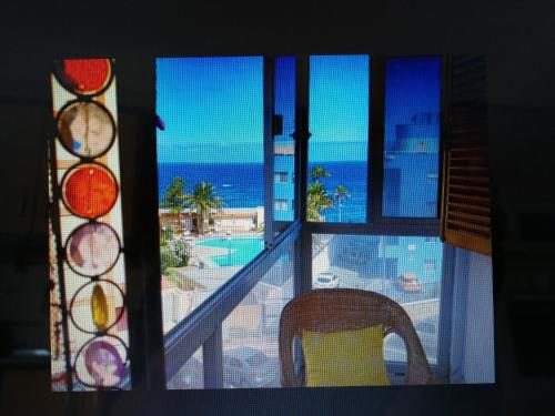 una finestra con vista sull'oceano e una sedia di MAGIC SUN Loft a Candelaria