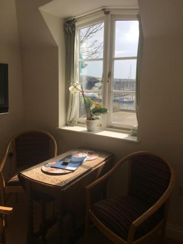 a table and chairs in a room with a window at The Steam Packet in Littlehampton