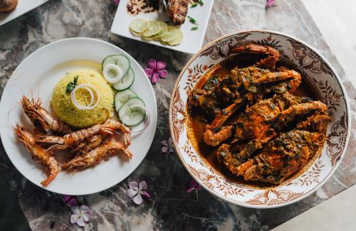 a table with a plate of food and a bowl of shrimp at Luna Laguna in Kalpitiya