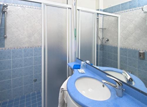 a blue bathroom with a sink and a shower at Hotel Villa Lieta in Rimini