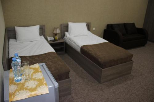 a hotel room with two beds and a chair at Liel in Tbilisi City