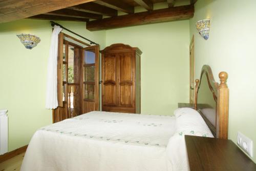 a bedroom with a bed and a wooden cabinet at Viviendas Rurales Peña Sagra in Cahecho