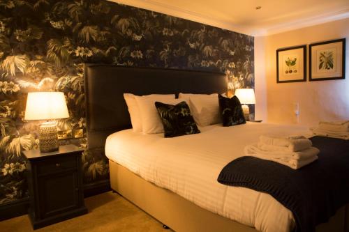 a bedroom with a large bed with a black wall at Wynnstay Arms, Ruabon, Wrexham in Ruabon