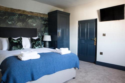 a bedroom with a large bed with towels on it at Wynnstay Arms, Ruabon, Wrexham in Ruabon