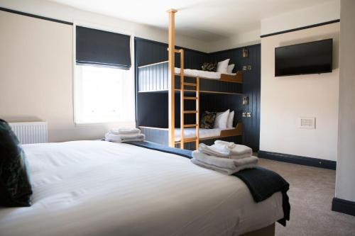 a bedroom with a large bed with a bunk bed at Wynnstay Arms, Ruabon, Wrexham in Ruabon