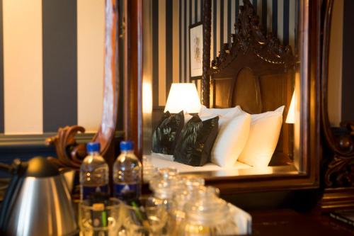 a bed with a mirror and bottles on a table at Wynnstay Arms, Ruabon, Wrexham in Ruabon