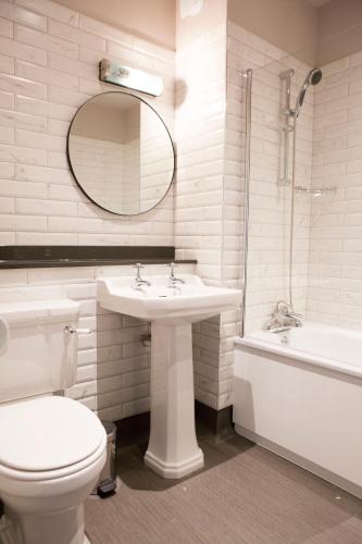 a bathroom with a toilet and a sink and a tub at Wynnstay Arms, Ruabon, Wrexham in Ruabon