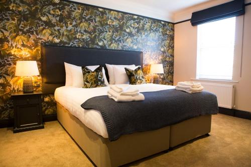 a bedroom with a bed with towels on it at Wynnstay Arms, Ruabon, Wrexham in Ruabon