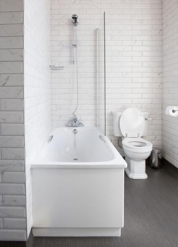 a white bathroom with a tub and a toilet at Wynnstay Arms, Ruabon, Wrexham in Ruabon
