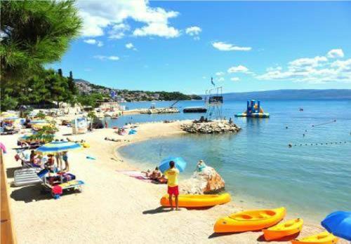 a beach with a bunch of people in the water at Apartment Josipa in Split