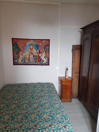 オーにあるAULT ruelle saint Pierreのベッドルーム1室(ベッド1台付)、壁にタペストリーが備わります。