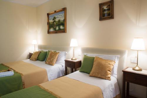 a hotel room with two beds and two lamps at B&B Mareagrò in Santa Teresa di Riva