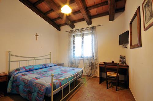 a bedroom with a bed and a cross on the wall at Agriturismo Casale Contessa in Montebuono