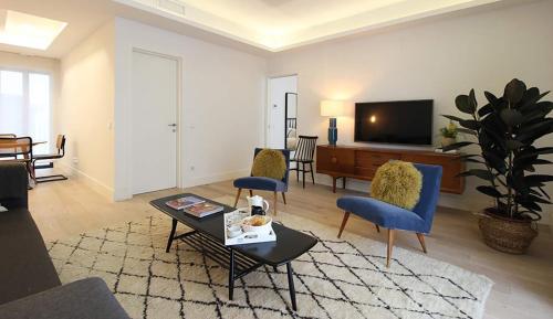 a living room with a couch and chairs and a tv at Exclusivo en Barrio de Salamanca in Madrid
