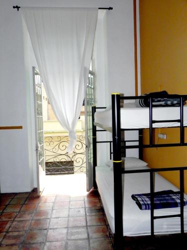 a room with bunk beds and a door with a window at Hostel Hospedarte Centro in Guadalajara