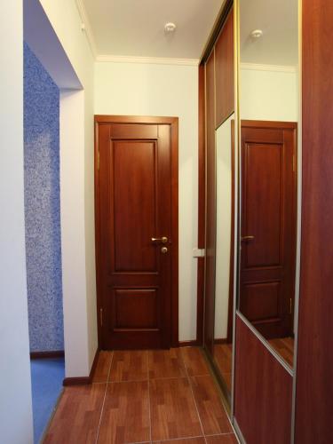 a hallway with two wooden doors and a mirror at Paradise Hotel in Svitlovodsʼk