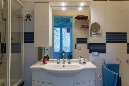 a bathroom with a sink and a mirror and a shower at Luxury Apartment and Charm Sea View Isola Bella in Taormina