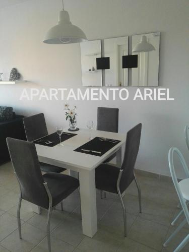 Un comedor con una mesa y sillas blancas. en Apartamento Ariel, en Peñíscola