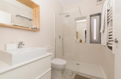 a white bathroom with a sink and a toilet at OrangeTreeHouses in Montijo