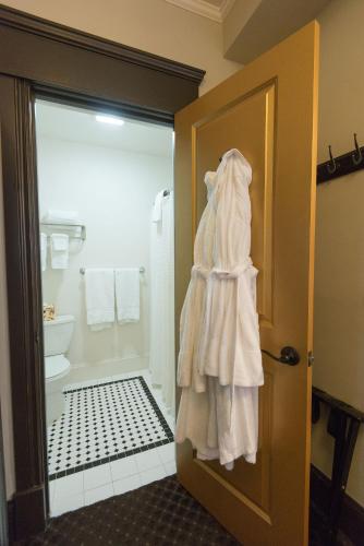 a white robe hanging on the door of a bathroom at Camas Boutique Hotel in Camas