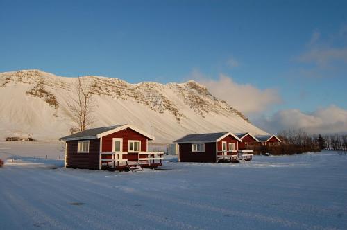 a row of houses in front of a snow covered mountain at Móar Cottage in Akranes