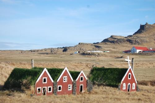 a group of houses in a field with grass at Móar Cottage in Akranes