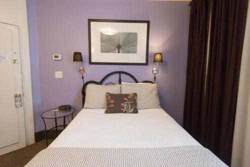 a bedroom with a bed with purple walls at Camas Boutique Hotel in Camas