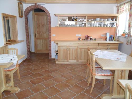 a kitchen with wooden cabinets and a tiled floor at Rooms and Apartments Jerman in Bled