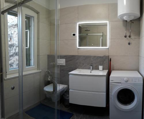 ein Badezimmer mit einer Waschmaschine und einem Waschbecken in der Unterkunft Centar Palace Apartment in Split