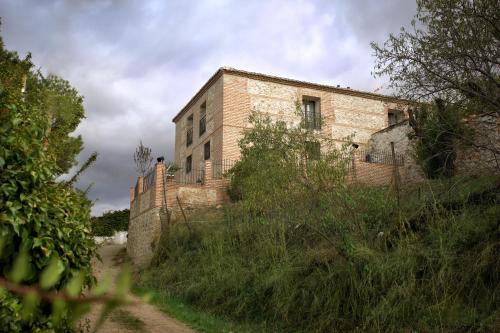 an old brick building on the side of a hill at El Pontifical in Los Santos de la Humosa