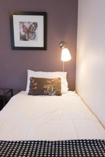 a white bed with a pillow on top of it at Camas Boutique Hotel in Camas