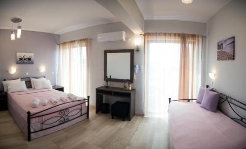 a bedroom with a large bed and a mirror at Galazio Limani - Rooms to let in Moúdhros
